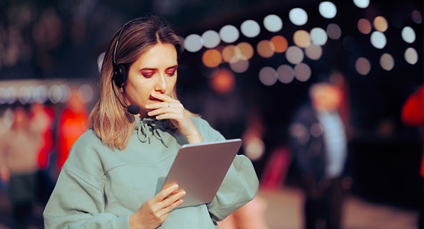 event planner wearing headphones looking at tablet